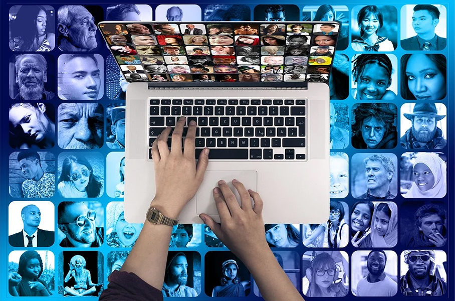 apple macbook with a series of thumbnail images of people, and two hands scrolling through them.