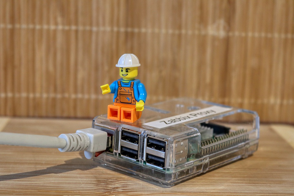 Image of a construction worker Lego figure sitting on top of a device connected to the internet by an ethernet cable and pointing to the cable.