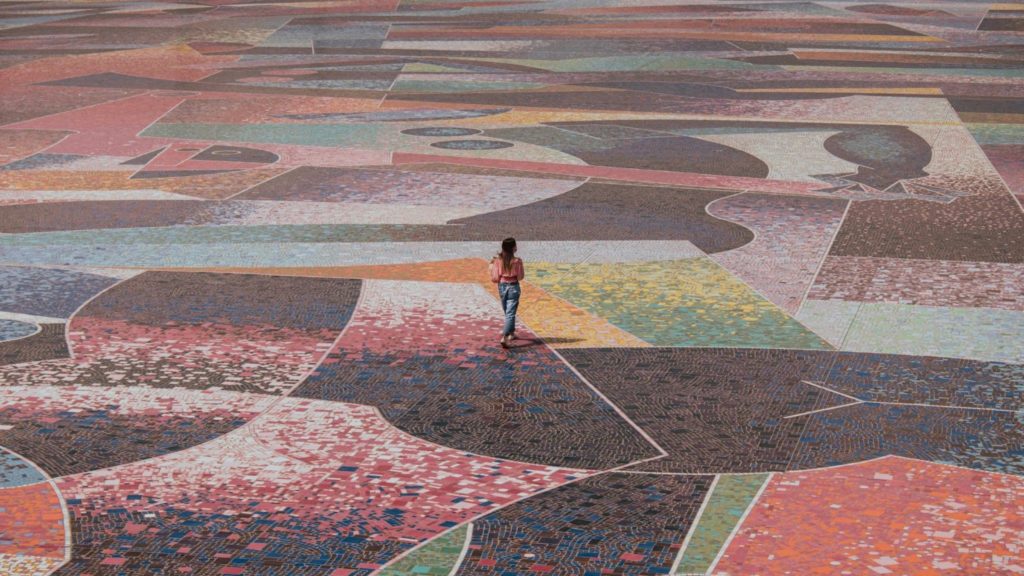 Image of a woman walking on large tile design.