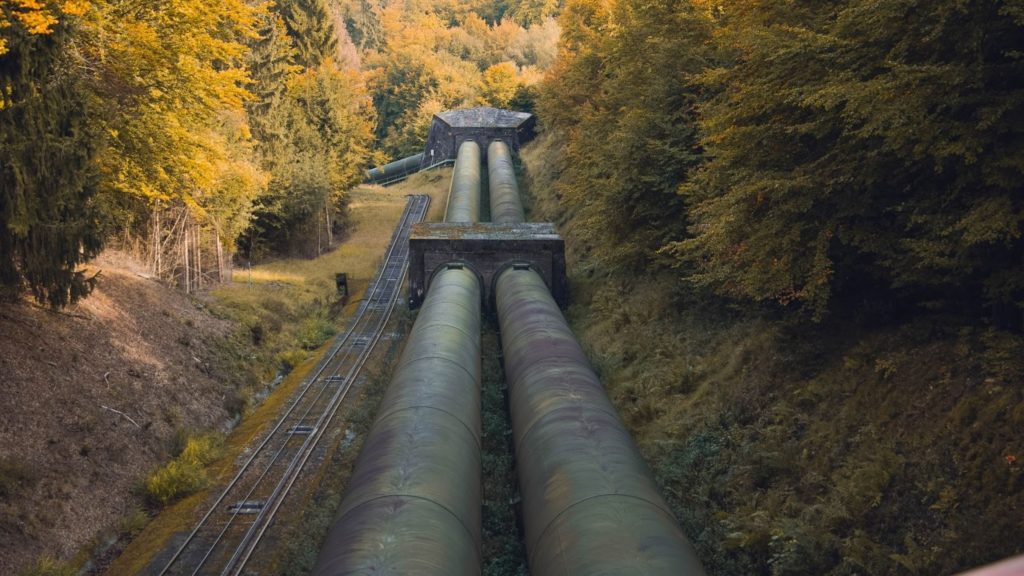Image of old oil pipelines running next to a train track.