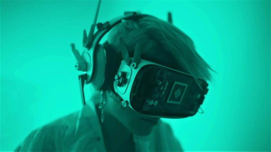 Image of a person using a heavily modded VR set under green light.