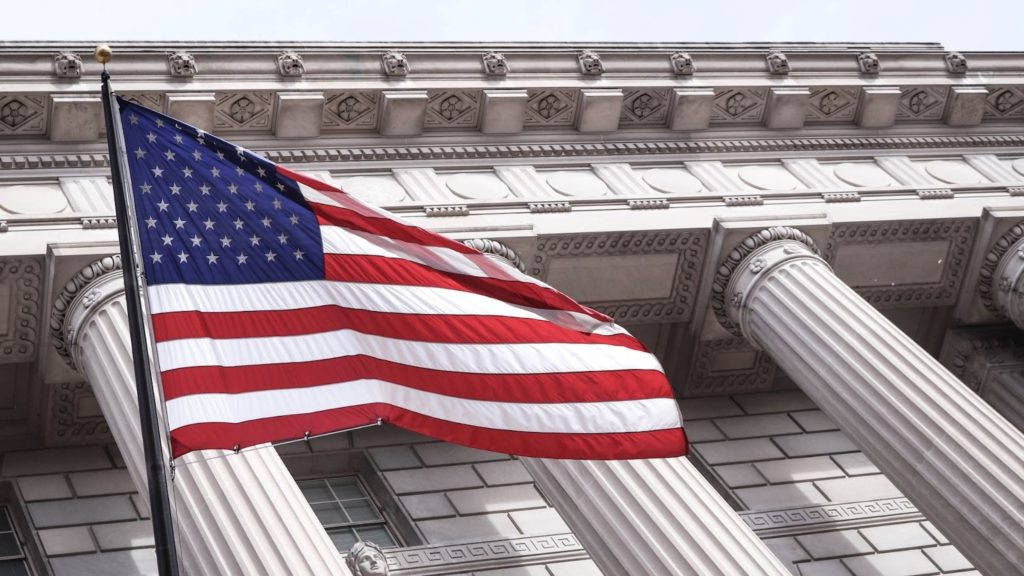 Image of a USA flag in front of the chamber of commerce.
