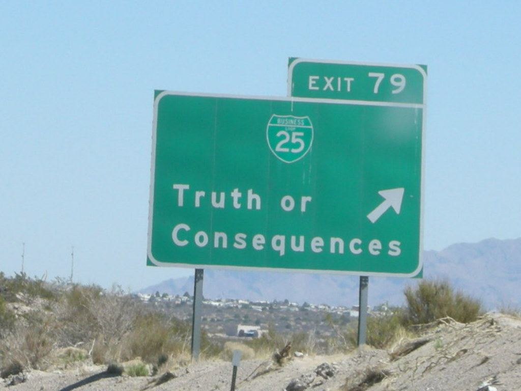 Image of a road sign with the words truth or consequences next to an arrow.