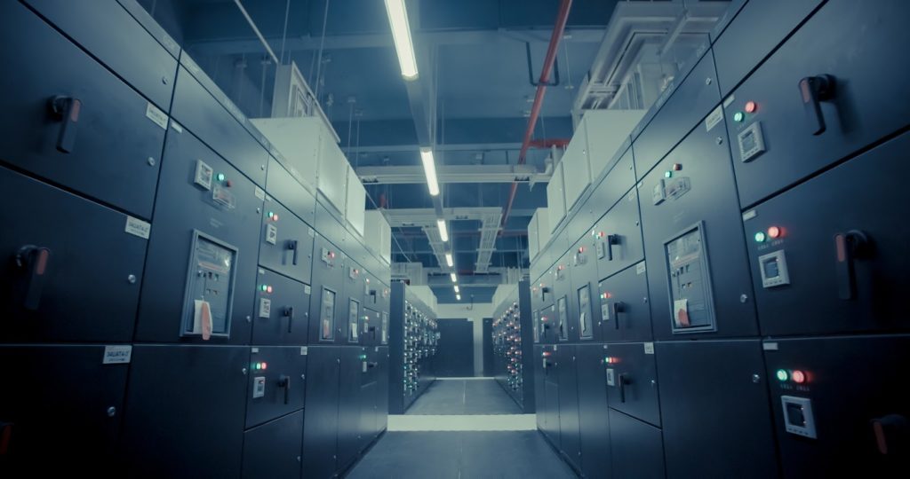 An image of an enterprise data center with a row of servers on each side of a hallway.