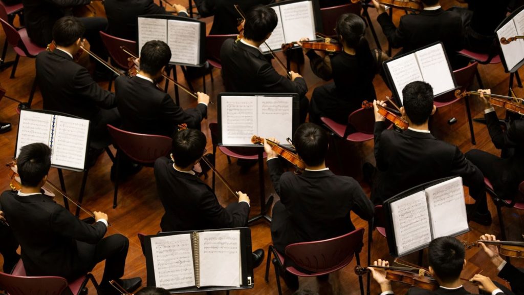  Image of a violin orchestra performing. 