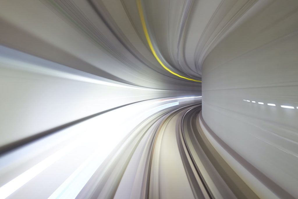 A photo of someone passing through a train tunnel at a high speed.