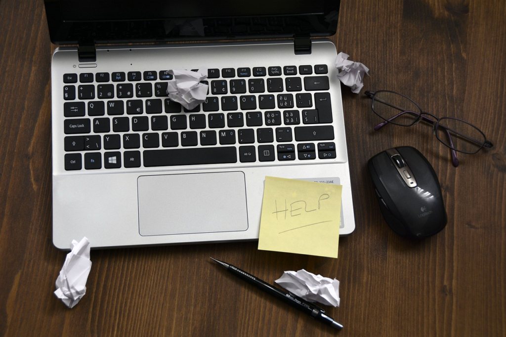 An image of a note on a laptop that reads "Help".