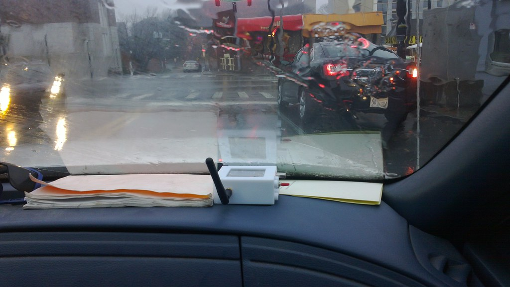 Image of a Wardriving box on dashboard of car in traffic.