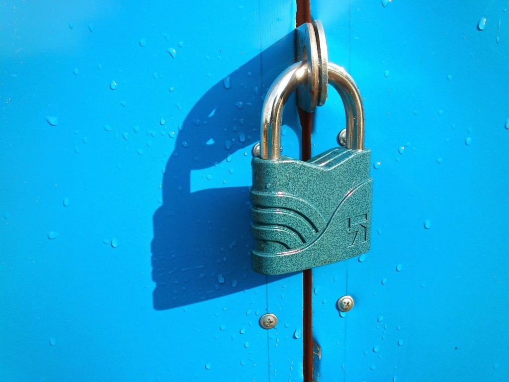 The image shows a blue lock against a bright-blue door.