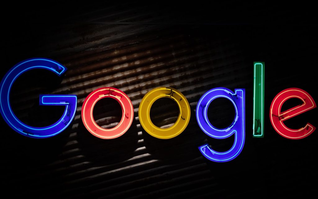 The image shows Google's logo colorfully lit against a dark background.