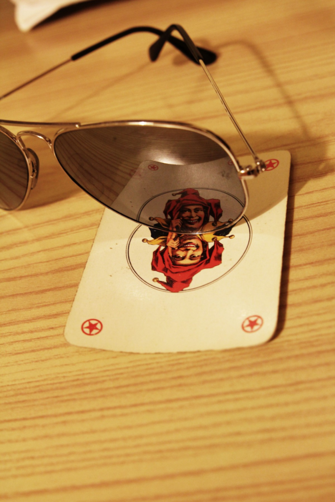 Image of sunglasses resting on a playing card.