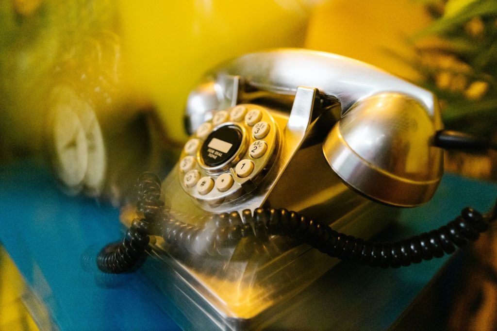 The image shows a picture of an old-fashioned telephone with a yellowish hue.